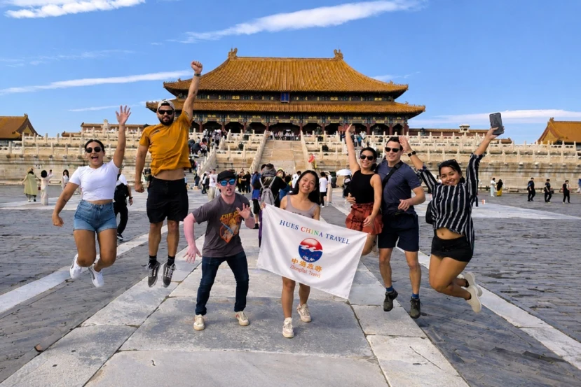 Young travelers jumping at Forbidden City